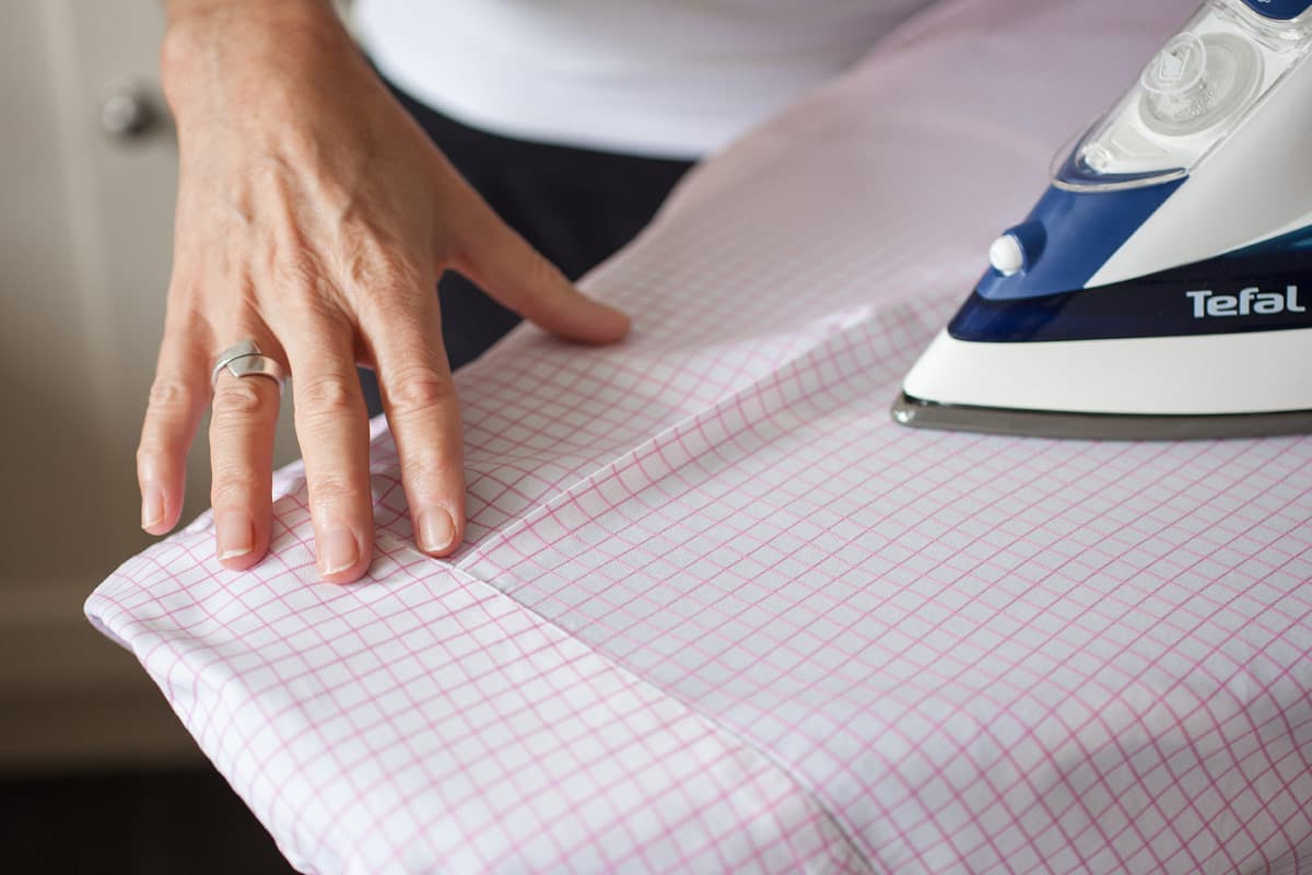 Pink gingham shirt being ironed
